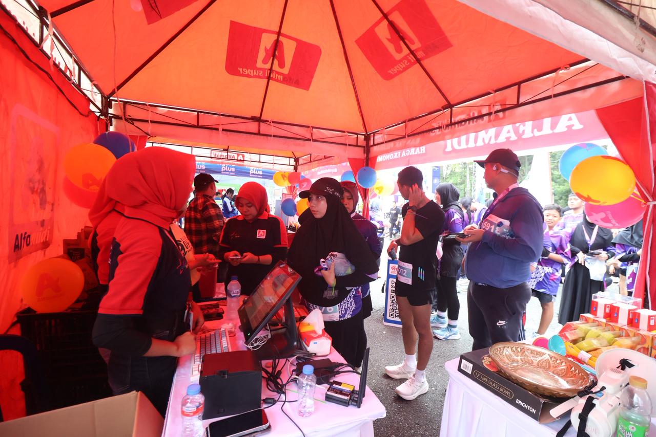 SAHABAT KELUARGA: Peserta BSI Kaltim Post Runstoppable antusias membeli berbagai produk yang disuguhkan Alfamidi, paling tinggi buah segar.