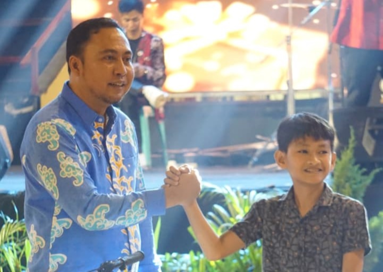 Bupati Kutai Barat Frederick Edwin (kiri) menyalami Jiovanno yang memenangkan undian sepeda.