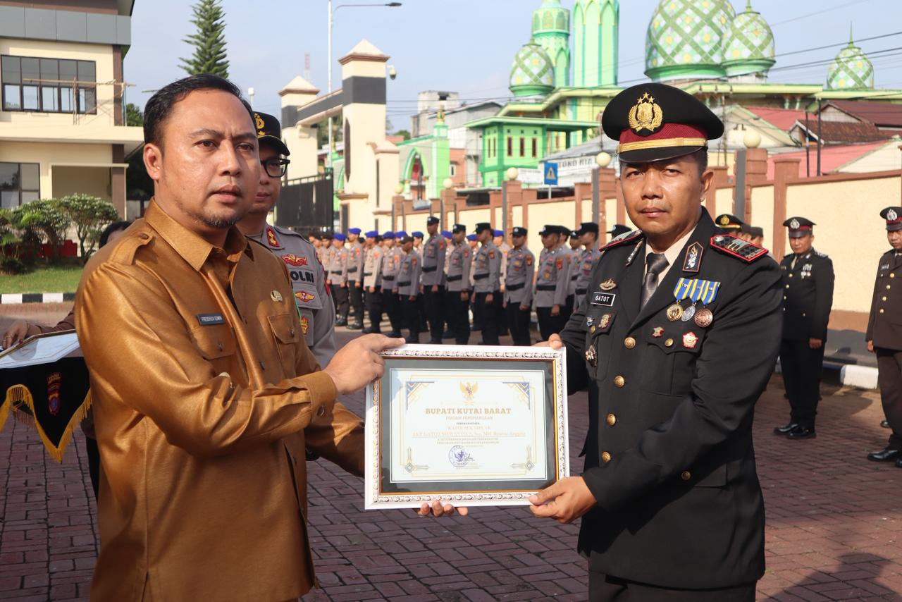 Bupati Frederick Edwin (kiri) menyerahkan penghargaan di Mapolres Kubar.  &nbsp;