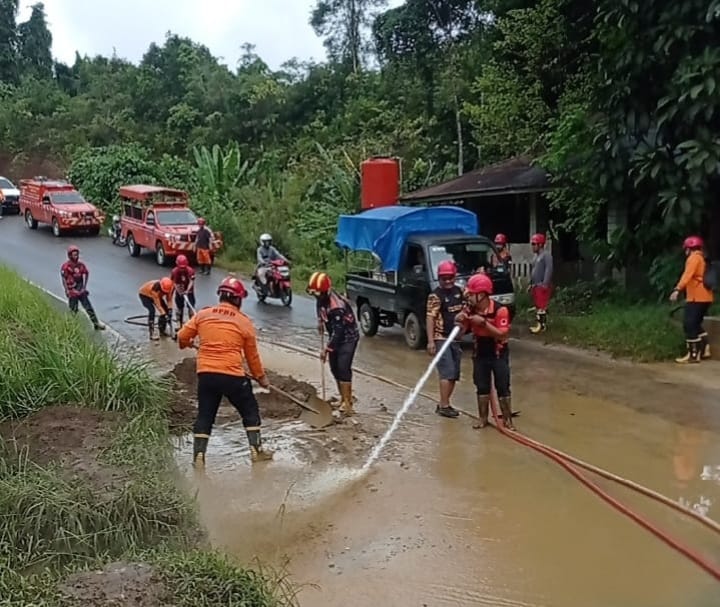 KERJA KERAS: Tim BPBD Kutai Barat melakukan pembersihan ruas jalan yang dipenuhi lumpur.