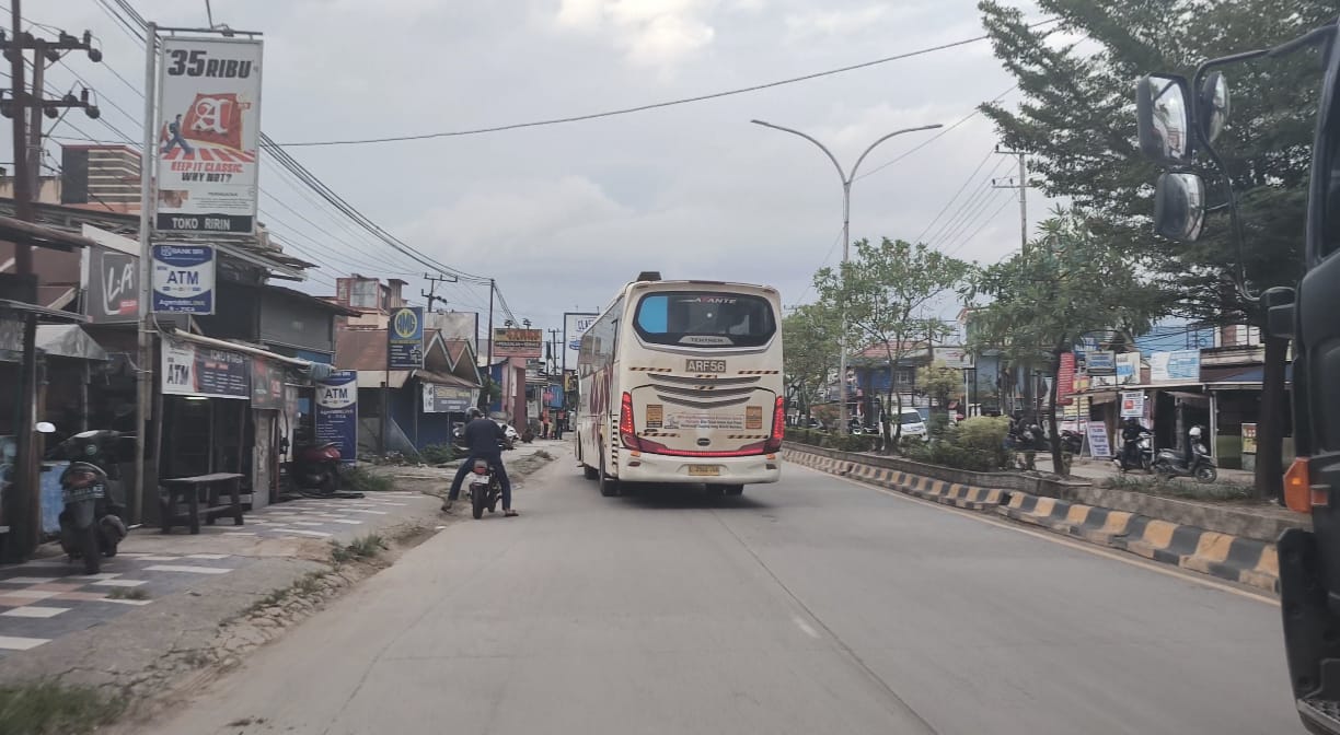 Bus perusahaan melintas di Jalan Yos Sudarso, Sangatta Utara, kawasan yang dikeluhkan warga karena rawan kecelakaan.