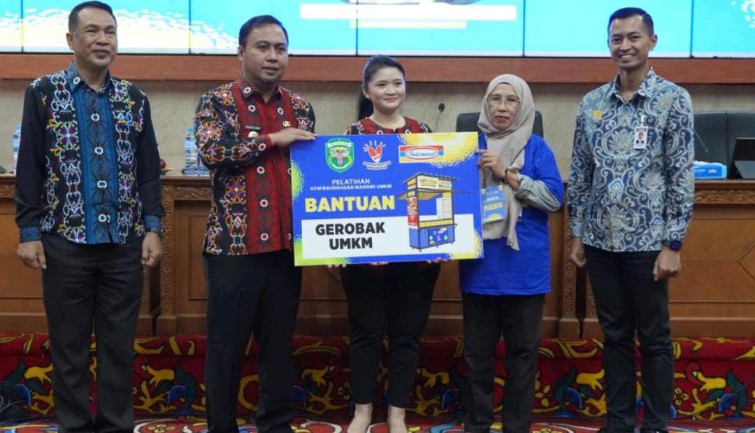 SERAHKAN: Penyerahan Bantuan 1 Unit Gerobak UMKM dari Indomaret yang diserahkan Bupati Kutai Barat Frederick Edwin (kanan) ditemani ketua TP PKK Kutai Barat Maria Christina Mozes Edwin (tengah).