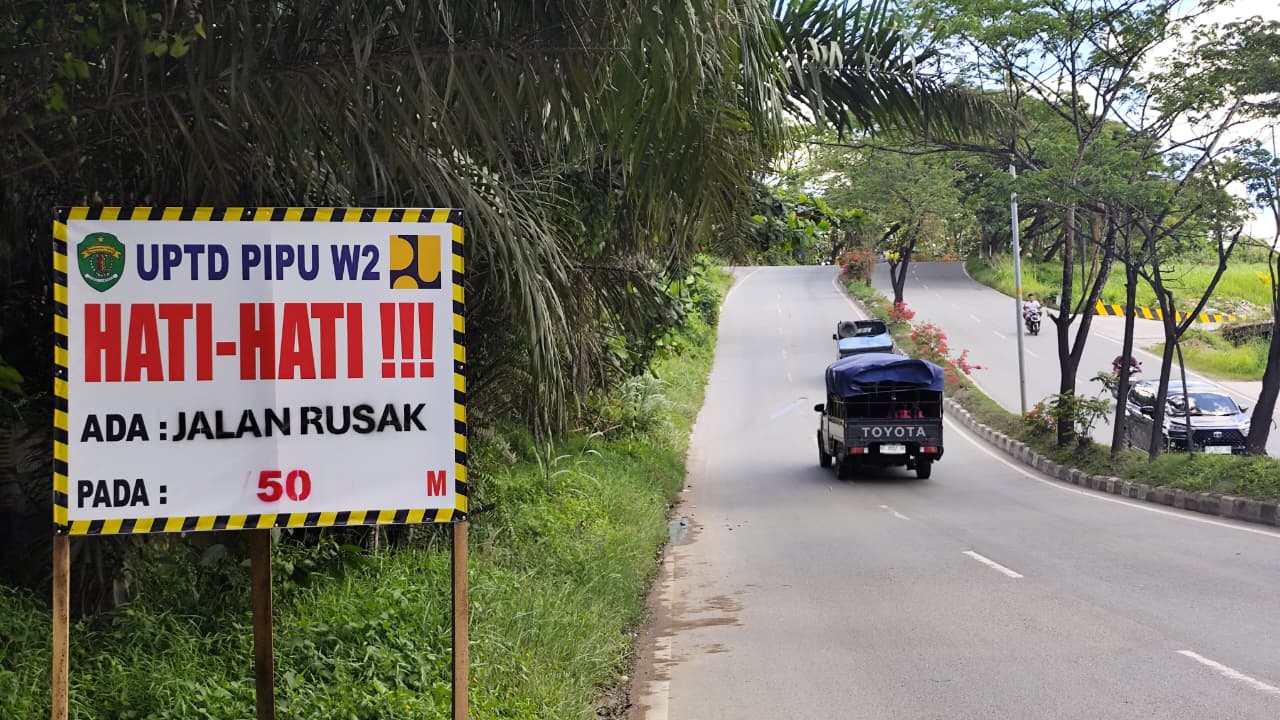 WASPADA: Spanduk peringatan dipasang tim UPTD Wilayah II DPUPR Pera Kaltim di dekat titik badan jalan yang terangkat di Jalan P Suryanata Kecamatan Samarinda Ulu, Kamis (5/2).