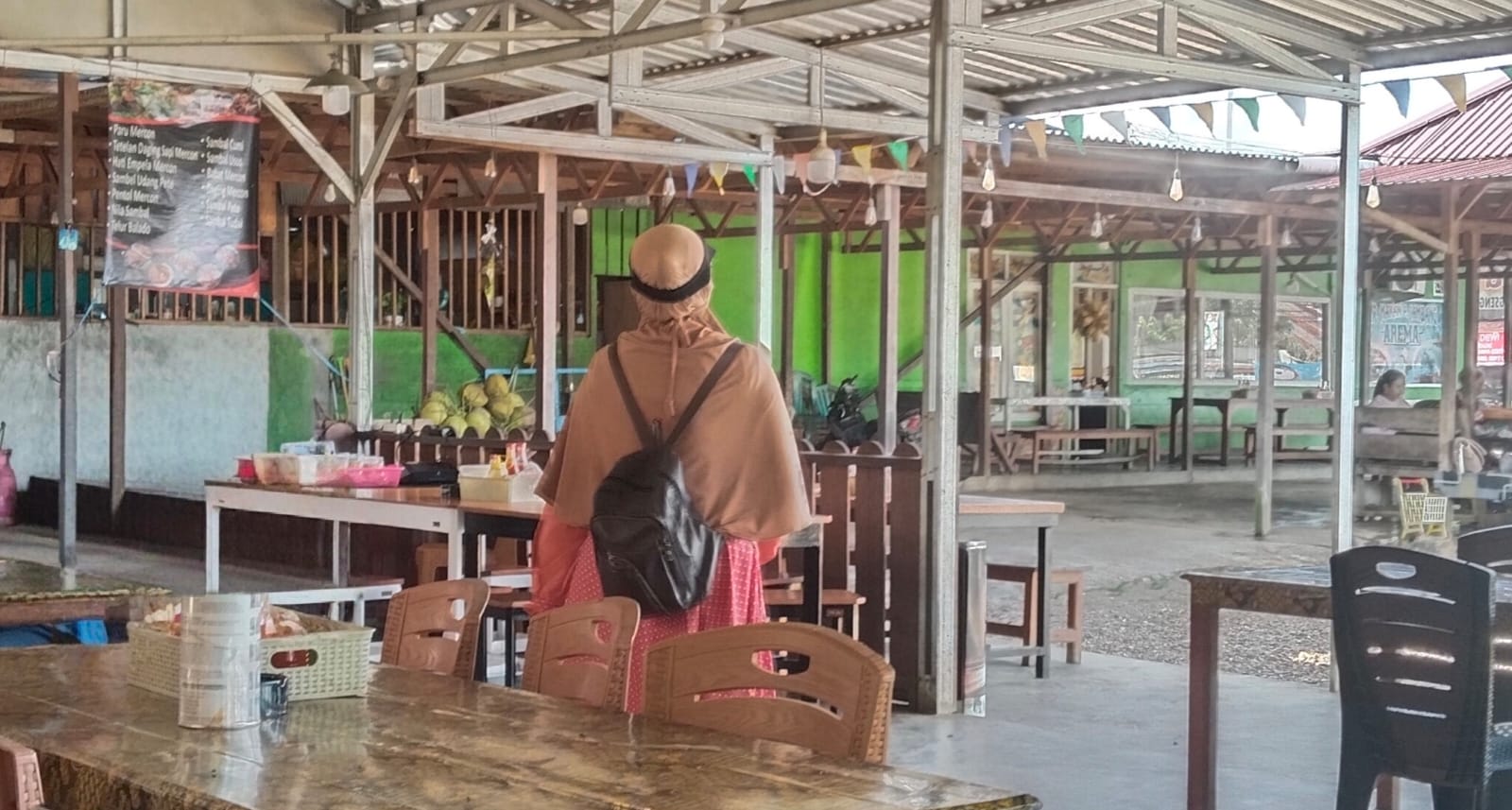 DIKELUHKAN: Salah seorang wanita tampak mendatangi sejumlah warung untuk meminta-minta ke pengunjung.
