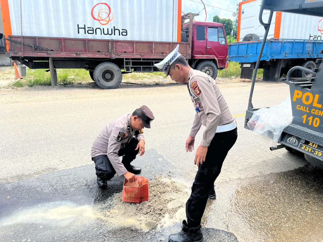 MENGURUK: Personel Polsek Babulu, Polres PPU menguruk lubang menganga di jalan trans Kaltim-Kalsel.