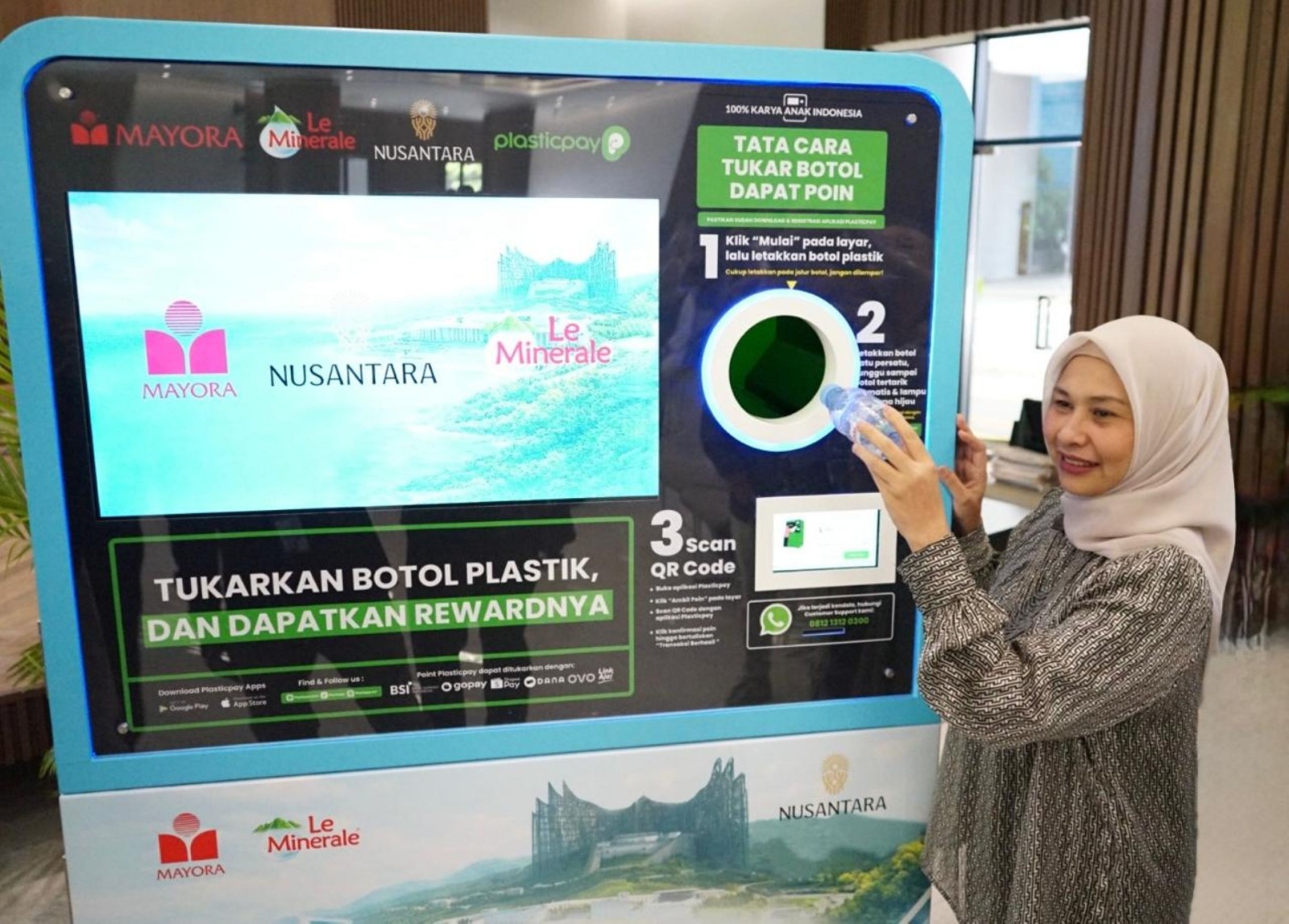 Deputi Lingkungan Hidup dan Sumber Daya Alam Otorita IKN, Myrna A. Safitri, mencoba Reverse Vending Machine (RVM) Plastic Pay untuk botol plastik PET pascakonsumsi. (Foto: Istimewa)