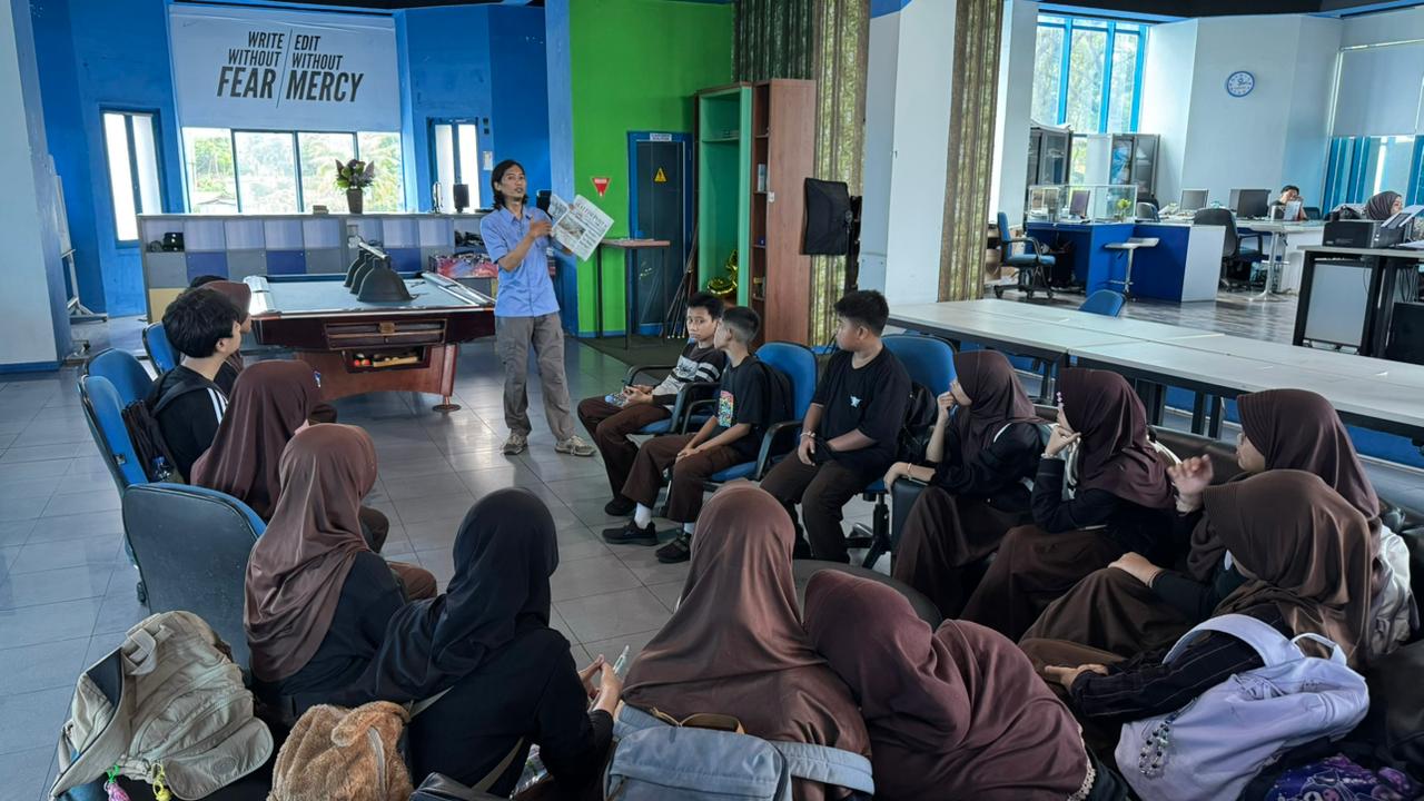 Murid SMP 5 Balikpapan eskul jurnalistik mendengarkan penjelasan proses produksi koran dari awak redaksi Kaltim Post.