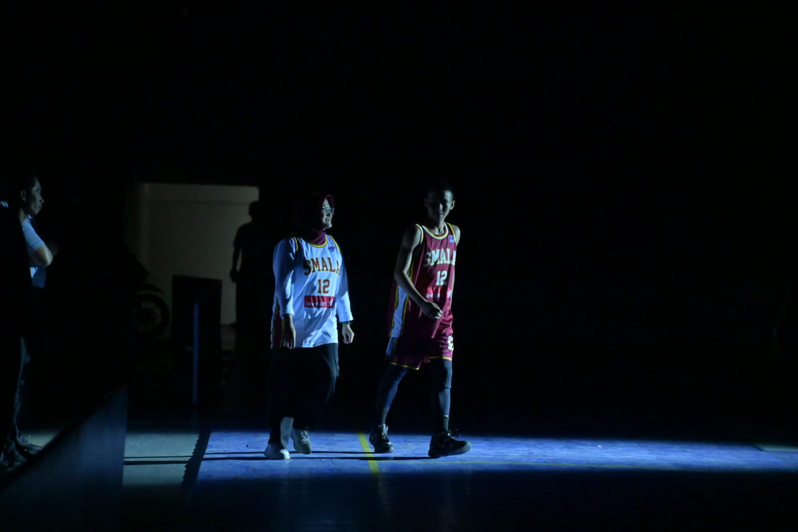 Seorang pemain SMA 5 Balikpapan bersama guru favoritnya saat memasuki lapangan pada opening party Honda DBL Kaltim 2026 di GOR Segiri Samarinda, Jumat (6/2).