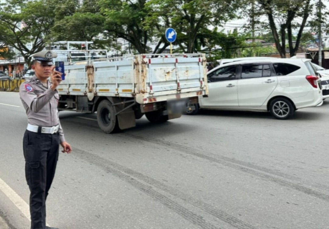 ETLE: Petugas menggunakan Electronic Traffic Law Enforcement (ETLE) Mobile Handheld dalam melakukan penindakan pelanggaran lalu lintas.