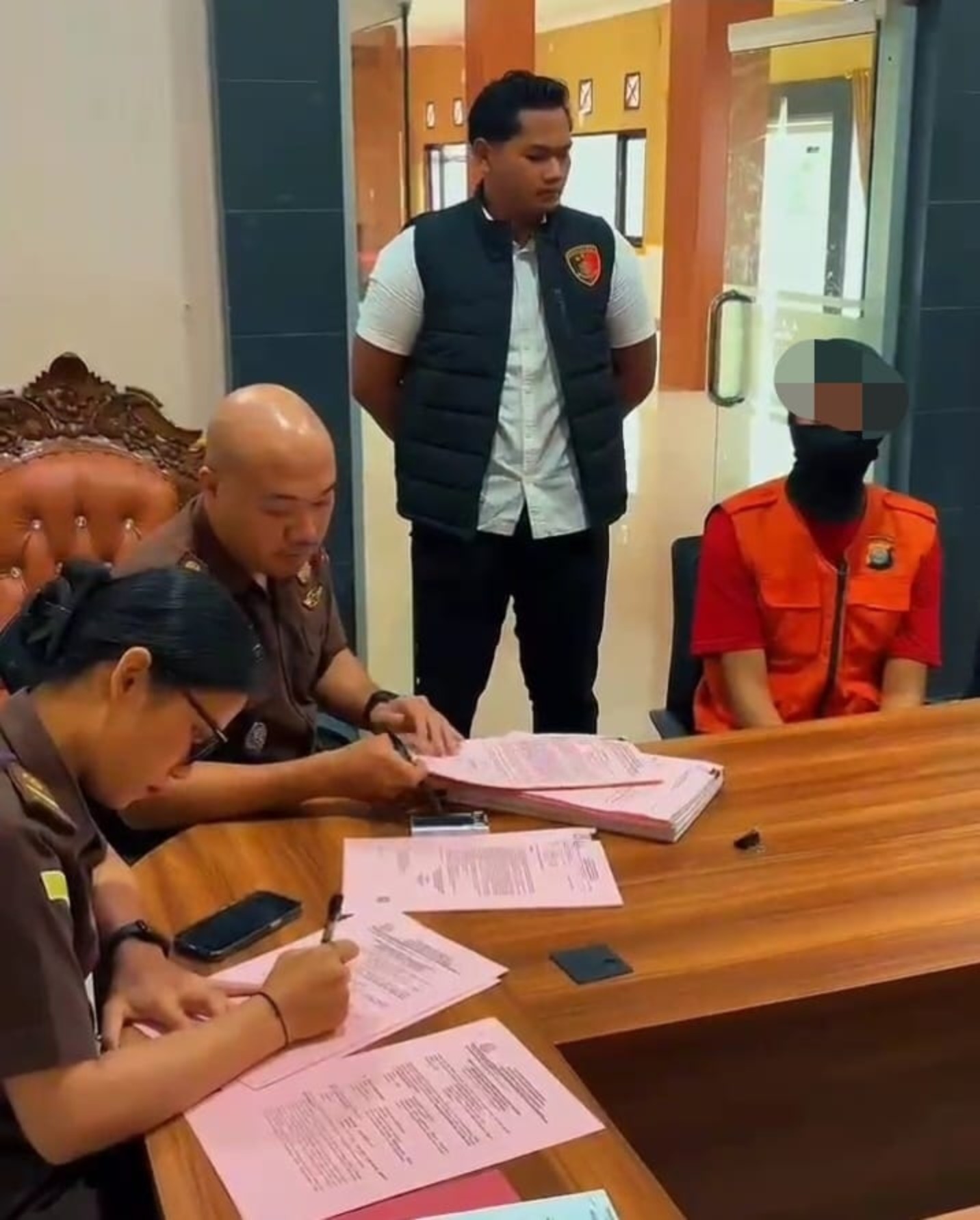 Pelaku R (kanan) saat diserahkan ke Kejaksaan Negeri Sendawar.