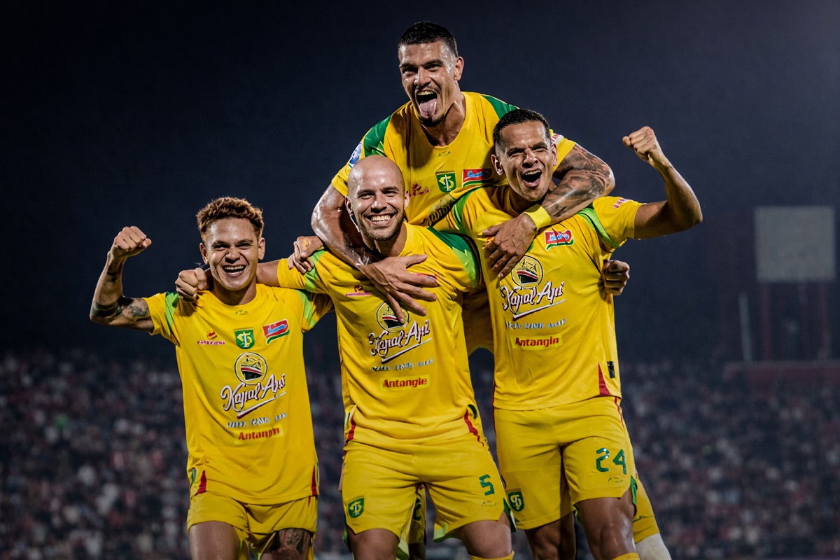 Pemain Persebaya Surabaya merayakan kemenangan saat laga tandang dengan jersey kuning. Green Force kini mencatat 13 laga tanpa kekalahan di Super League.