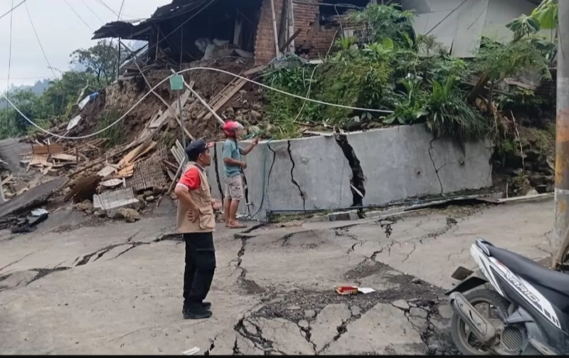 Kondisi rumah warga dan badan jalan di Desa Padasari, Kecamatan Jatinegara, Kabupaten Tegal, mengalami retakan parah akibat pergerakan tanah yang masih berlangsung, Senin (9/2/2026). (Foto Jawa Pos)