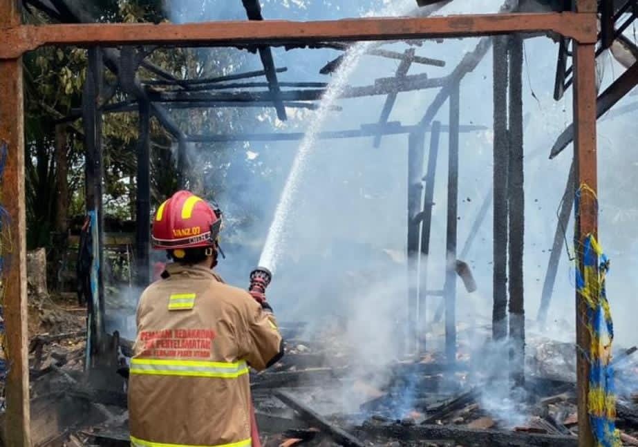 Petugas BPBD berupaya melakukan pendinginan lokasi kebakaran di tengah pemukiman warga Semoi Dua.  &nbsp;