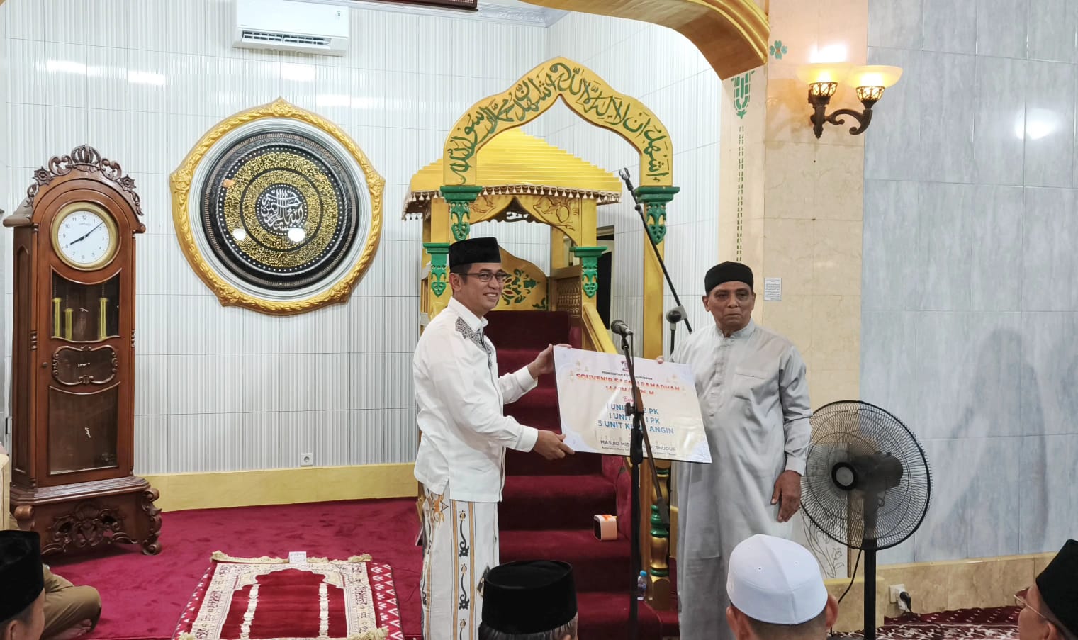 BANTUAN: Ketua Harian Masjid Mishbahush Shudur (kanan) menerima bantuan penunjang ibadah.  