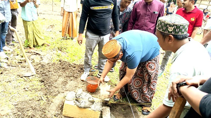 Haji Her melakukan peletakan batu pertama program bedah rumah warga miskin dari keuntungan program MBG di Desa Pangeleyan, Bangkalan, Selasa (3/3).