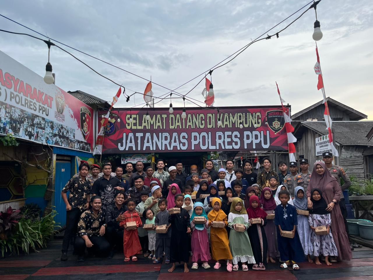 TAKJIL: Personel Satreskrim Polres PPU diabadikan bersama penerima takjil di Kampung Jatanras Penajam, PPU.