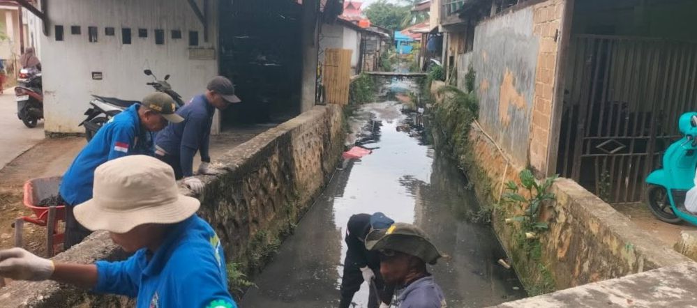 ANGKUT SEDIMEN: Petugas harian lepas dari Dinas PUPRK Bontang melakukan pembersihan saluran drainase di sekitar Pasar Telihan.&nbsp;