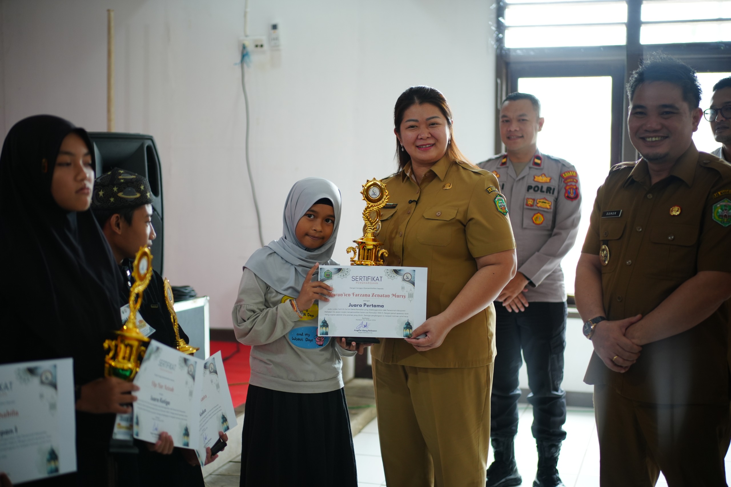 Bupati Mahakam Ulu, Angela Idang Belawan, saat menyerahkan hadiah kepada salah satu pemenang lomba Gema Ramadhan 2026. Kegiatan ini diikuti oleh peserta mulai tingkat TK hingga dewasa.