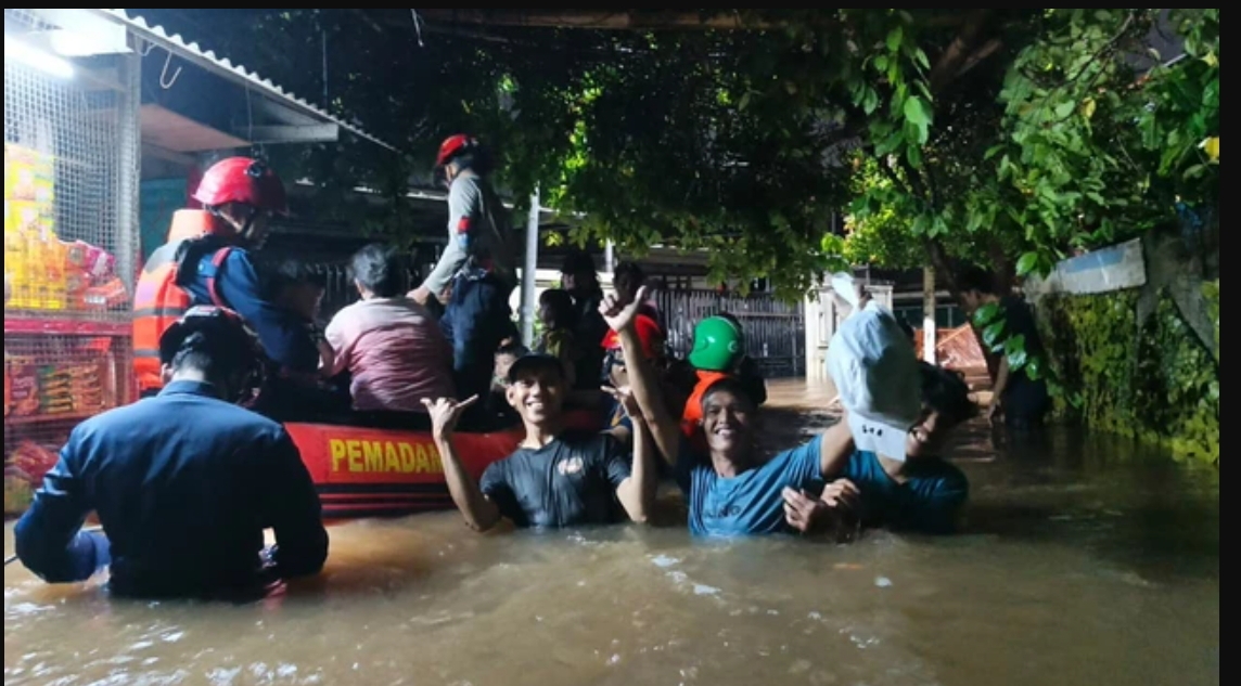Petugas mengevakuasi warga menggunakan perahu karet saat banjir merendam permukiman di Pekayon, Pasar Rebo, Sabtu (21/3/2026) malam. (FOTO: IST)