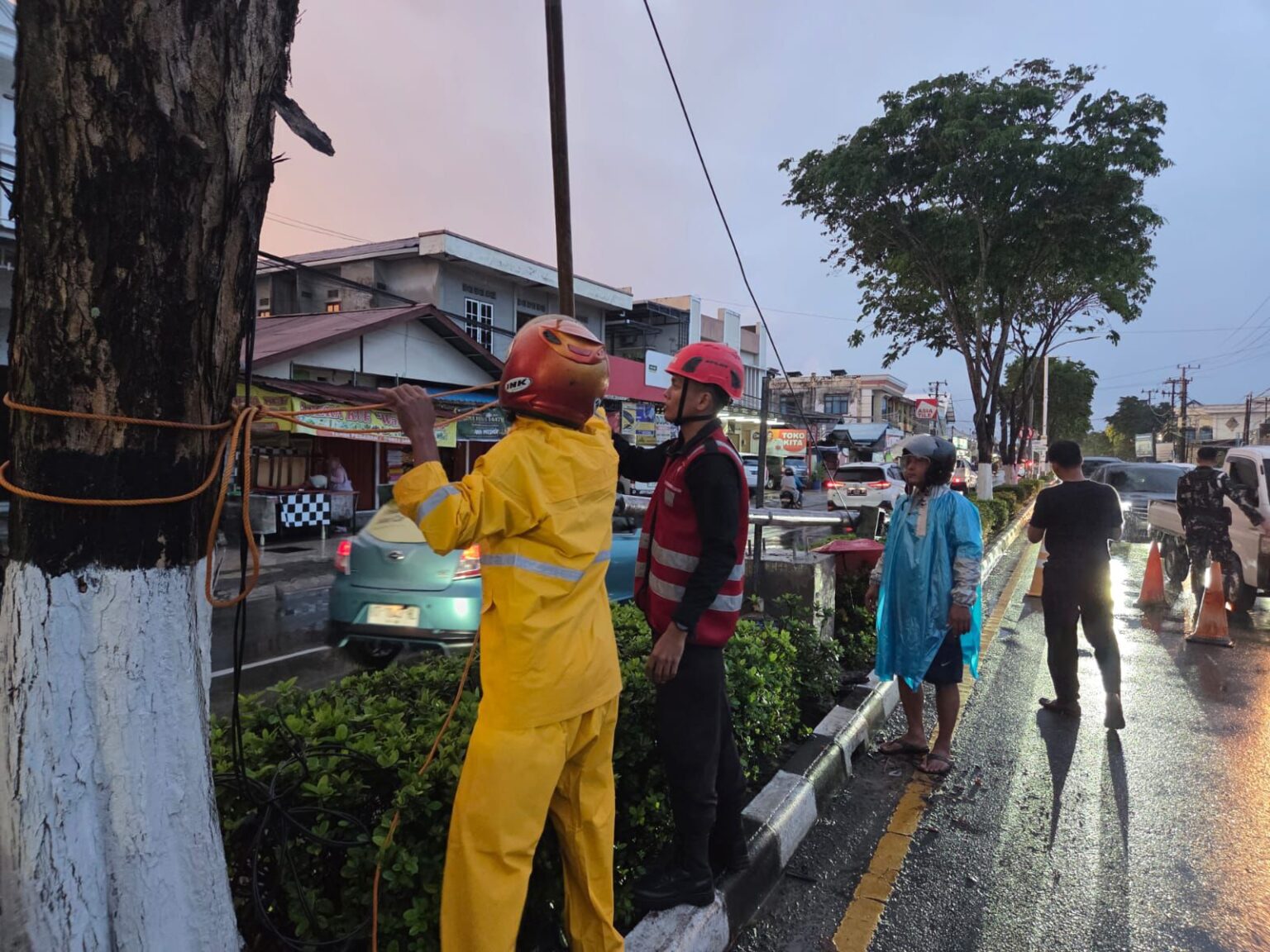 EVAKUASI: Petugas gabungan dan warga mengevakuasi tiang lampu yang tumbang dan menutup seluruh jalan hingga menimbulkan kemacetan.