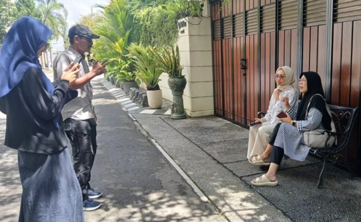 Pengunjung berfoto di depan kediaman Joko Widodo di Solo, yang viral sebagai &ldquo;tembok ratapan&rdquo; dan ramai dikunjungi saat libur Lebaran 2026. (FOTO: IST)