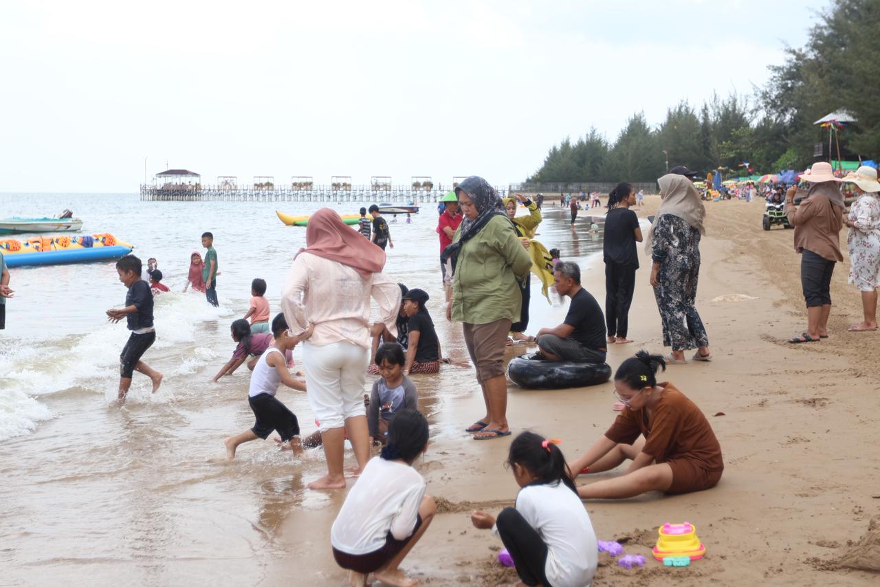BERBAHAGIA: Kunjungan wisatawan ke Pantai Manggar saat libur Lebaran cukup tinggi, ribuan orang tercatat.