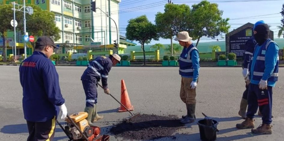 ATASI KERUSAKAN: Dinas PUPRK Bontang melakukan penambalan jalan rusak dengan skema sementara di simpang tiga RS Yabis. FOTO: ADIEL KUNDHARA/KP  