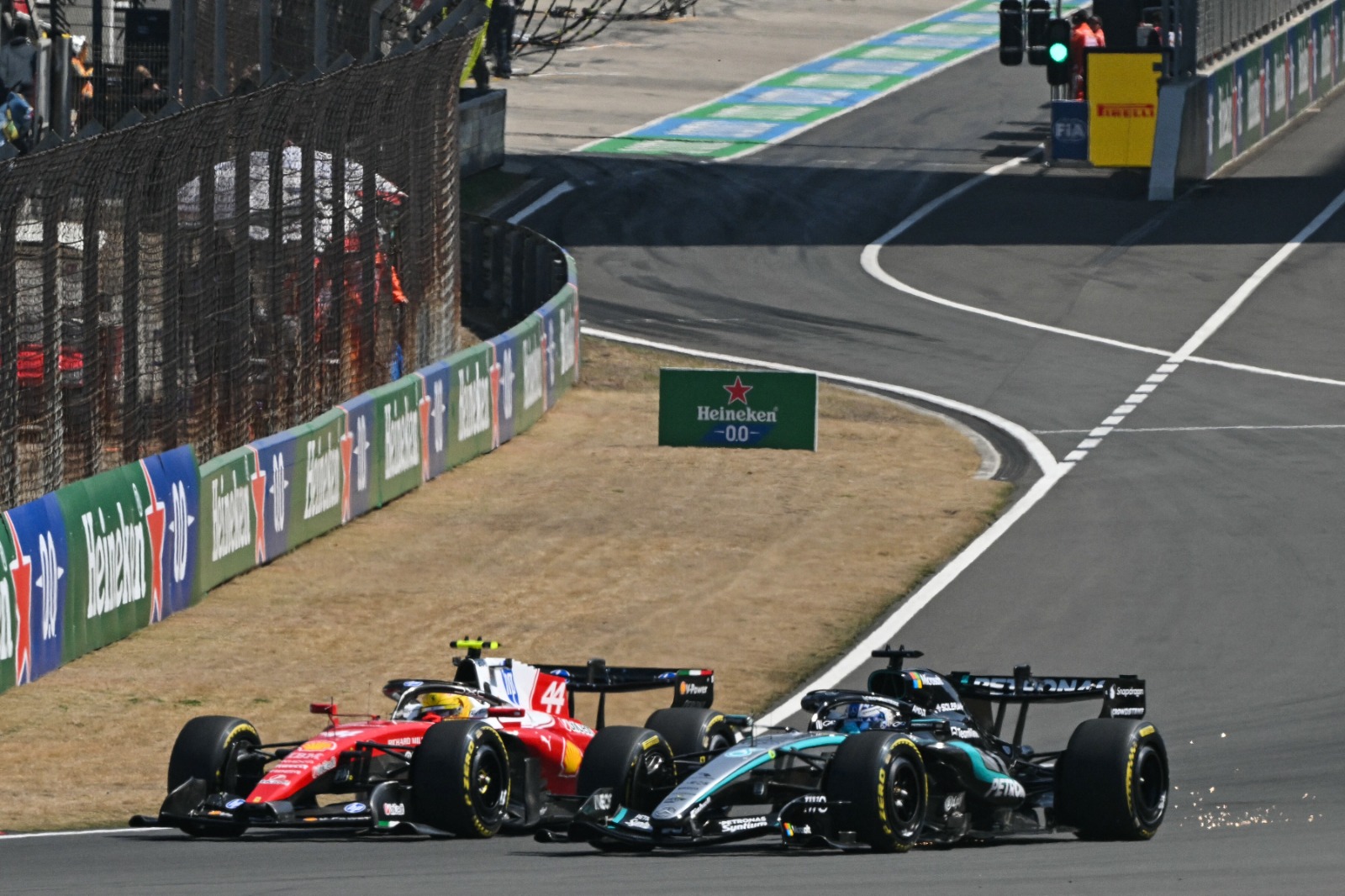 Pebalap Ferrari Lewis Hamilton (kiri) adu sprint dengan pebalap Mercedes George Russell pada balapan GP Tiongkok (14/3). 