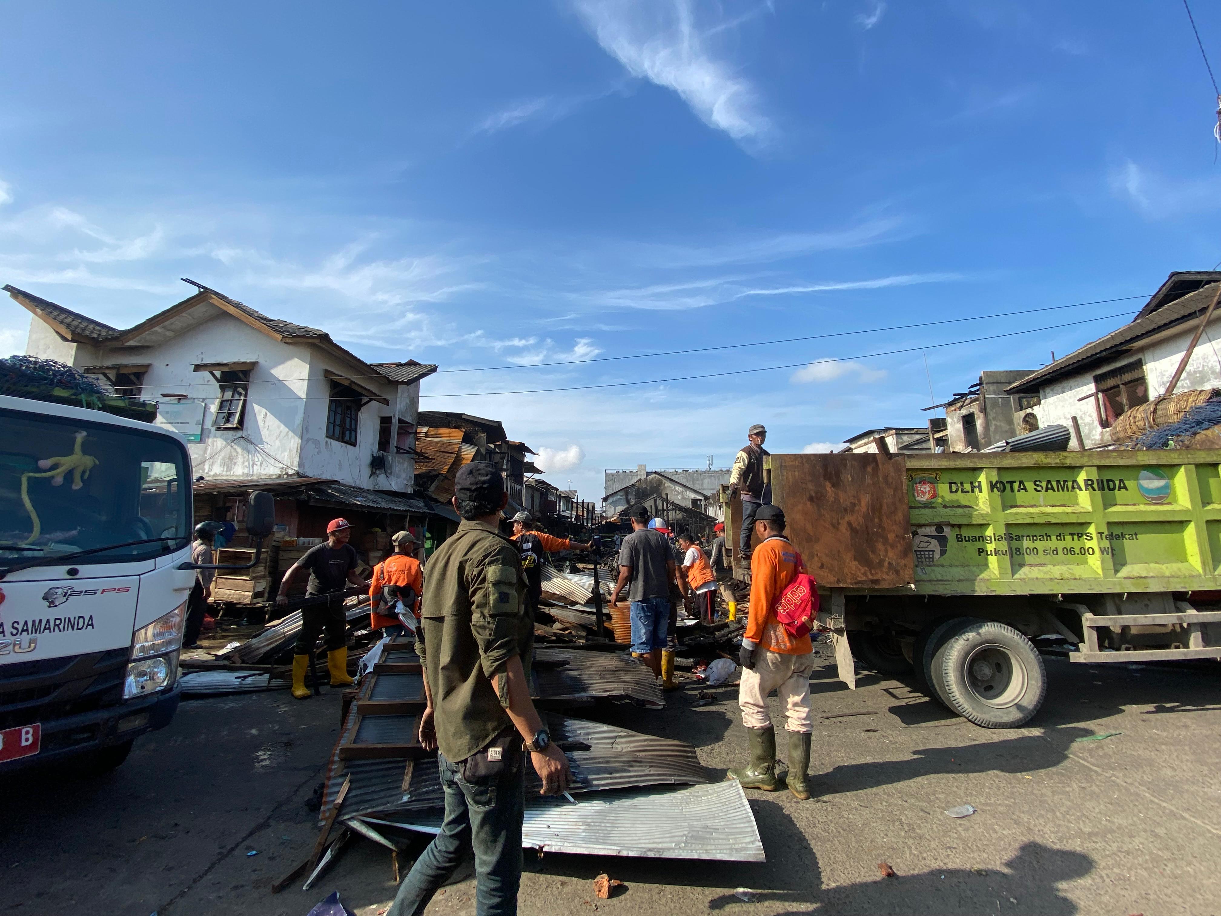 TELITI: Beberapa pekerja mengangkut puing sisa kebakaran pasar Segiri, dalam upaya pembersihan, Jumat (27/3).