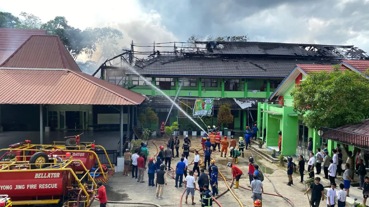 GERAK CEPAT: Tim gabungan Disdamkar dan Penyelamatan bersama relawan berupaya memadamkan api yang berkobar di SMP 2 Samarinda Jalan KH Ahmad Dahlan Kecamatan Samarinda Kota, Rabu (1/4). (RAMA SIHOTANG/KP)