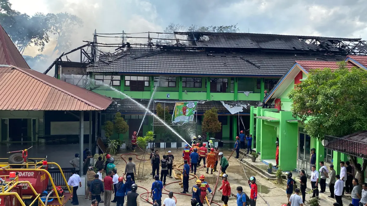 HANGUS: Petugas memadamkan kebakaran yang menghanguskan ruang kelas SMP 2 Samarinda, Rabu (1/4). (RAMA SIHOTANG/KP)&nbsp;