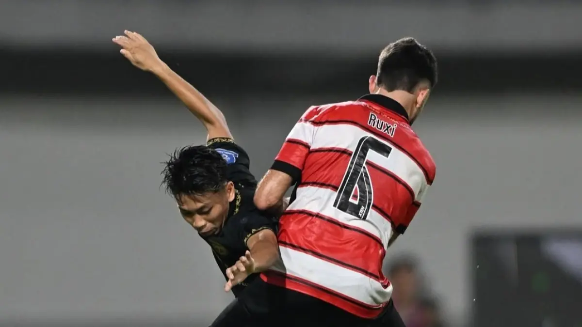 BERKESAN: Aan Redzuan (kiri) berduel dengan pemain Madura United dalam pertandingan debutnya bersama Borneo FC. 