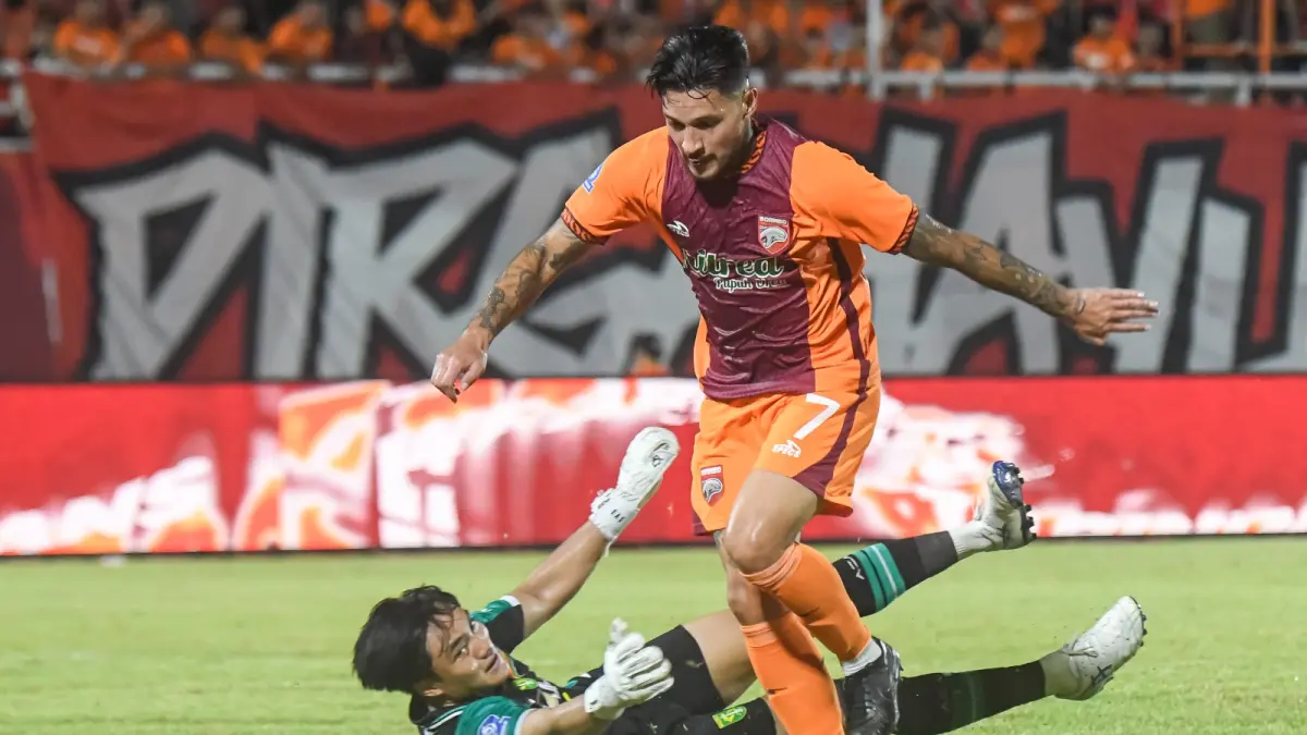 Kiper Persebaya, Ernando Ari Sutaryadi, berusaha menghalau pergerakan gelandang Borneo FC, Marcos Astina, dalam sebuah pertandingan. (M RISYAL HIDAYAT/ANTARA)