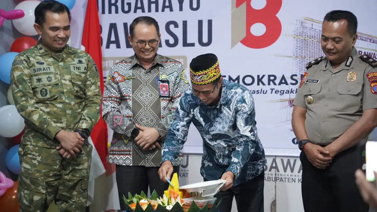DEMOKRASI: Ketua Bawaslu Kubar Lourensius (kanan) saat melakukan pemotongan tumpeng pada peringatan HUT Bawaslu. 