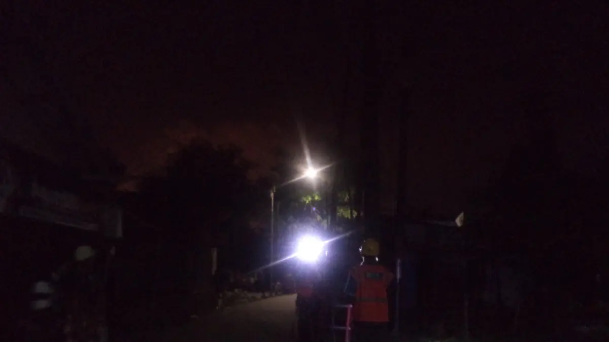 Petugas PLN memperbaiki jaringan listrik yang terbakar di kawasan Kayu Api RT 21, Kecamatan Penajam, Rabu malam (8/4/2026). Insiden ini sempat memicu kepanikan warga sekitar. (AHMAD MAKI/KALTIM POST)