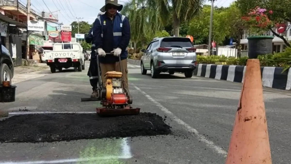 TAMBAL: Dinas PUPRK melakukan perbaikan jalan rusak di Bontang. ADIEL KUNDHARA/KP