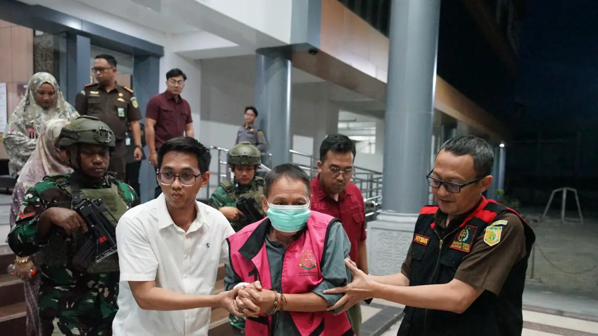 ROMPI TAHANAN: Tersangka AS, mantan Kepala Dinas Pertambangan dan Energi Kukar, saat digiring petugas menuju mobil tahanan di Gedung Kejati Kaltim, Samarinda. AS ditahan selama 20 hari ke depan di Rutan Samarinda untuk kepentingan penyidikan lebih lanjut. (KP)