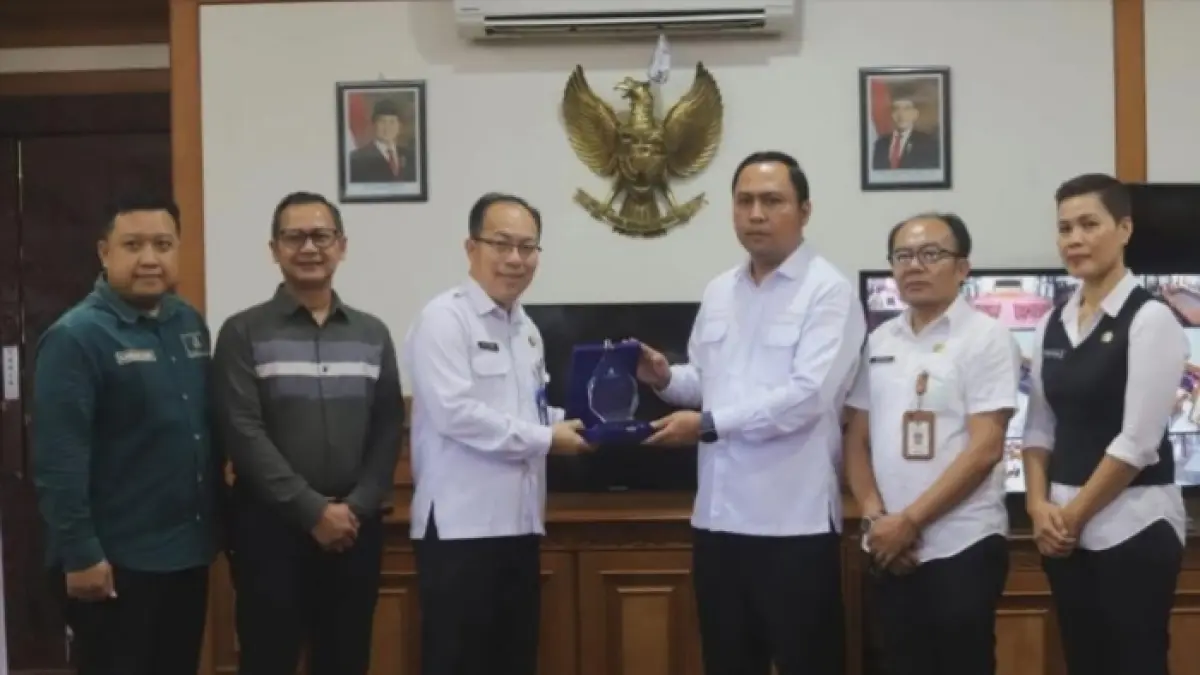 BOLEH BANGGA: Kepala BKAD Kubar, Petrus (tiga kiri) saat menyerahkan plakat penghargaan pemenang Terbaik 1 TP2DD kepada Bupati Kutai Barat, Frederick Edwin (tiga kanan).&nbsp;