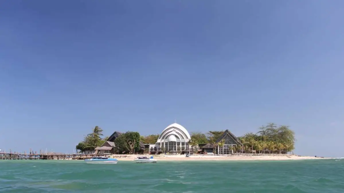 Tampak panorama Pulau Umang dengan deretan bangunan resort di tepi pantai, air laut berwarna hijau kebiruan, serta dermaga yang menjorok ke laut. (FOTO: IST)