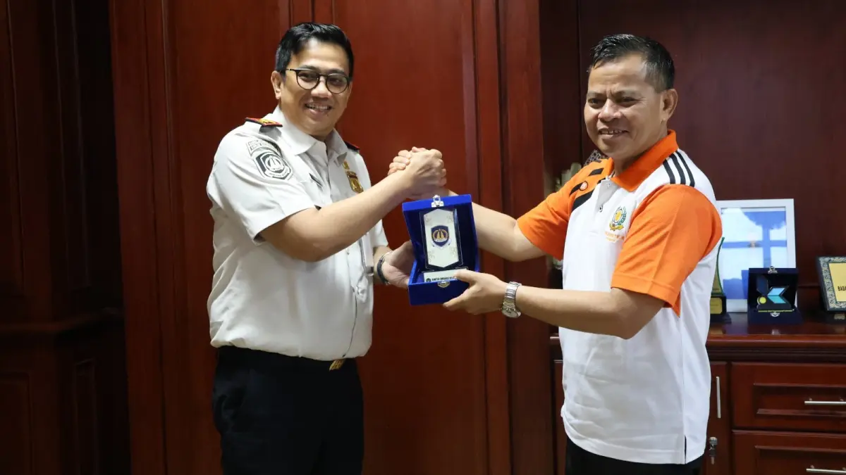 Adi Fachmianur (kiri) menyerahkan cendera mata kepada Tohar.
