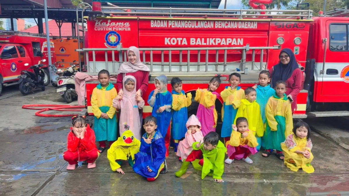 Selfie murid TK dan guru pembimbing di depan mobil pemadam kebakaran 