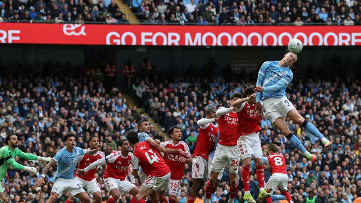 Erling Haaland memenangkan duel udara saat menghadapi Arsenal dalam laga Premier League. Striker Manchester City itu menjadi ancaman utama lewat kekuatan fisik dan kemampuan duel bola atas. (DARREN STAPLES/AFP)