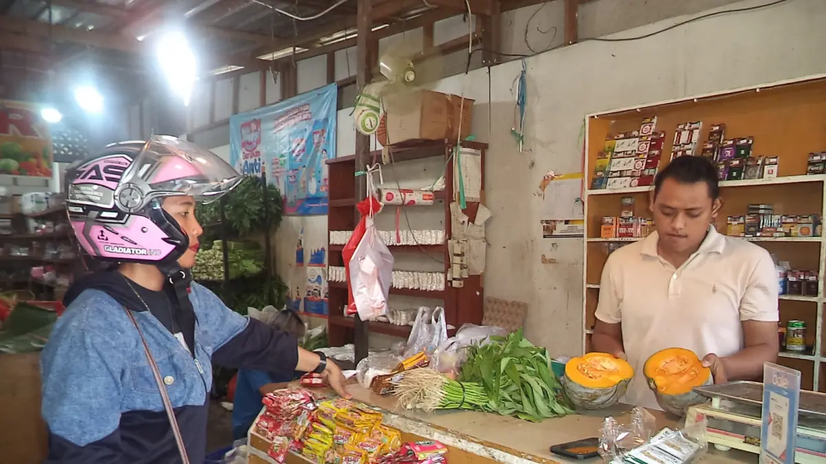 PELAYANAN PRIMA: Jainal (kanan), kasir Al Hasan Sayur saat melayani pembeli di Nenang, PPU. Harga komoditas sayur terpantau mulai melandai pasca-Lebaran. (AHMAD MAKI/KP)
