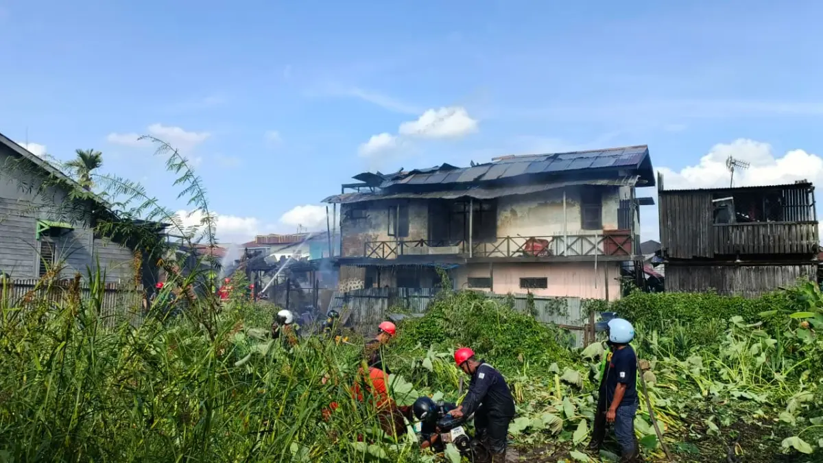 Petugas memanfaatkan air sungai Gang Masjid untuk mengatasi kebakaran di Jalan Lambung Mangkurat, Samarinda, Kamis (23/4). (HAFIZ/KP)