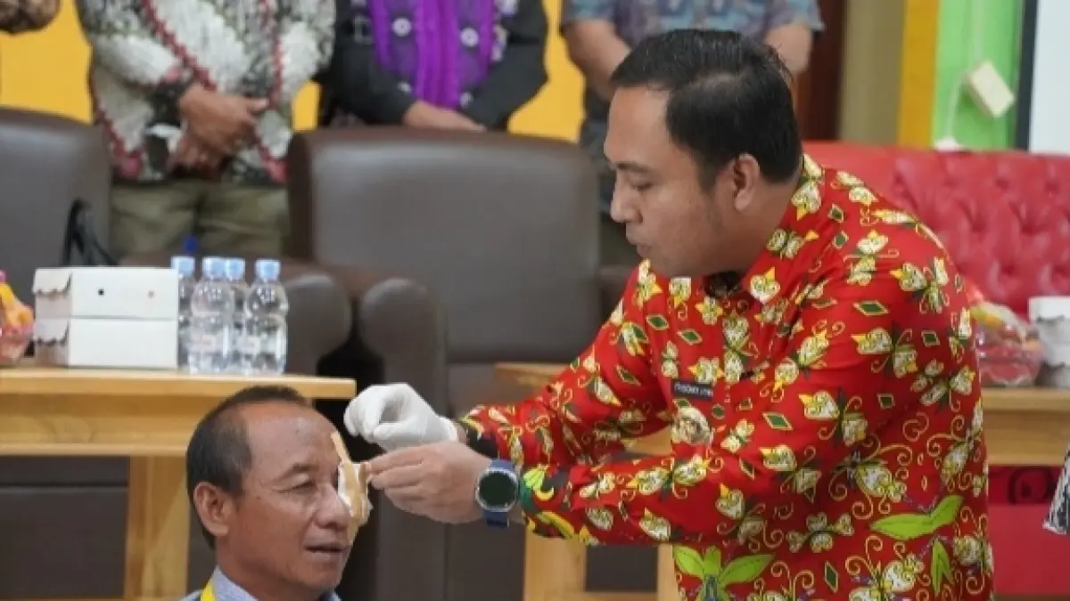 PERHATIAN: Bupati Kubar, Frederick Edwin (Kanan) saat buka perban salah satu pasien dari Long Iram.