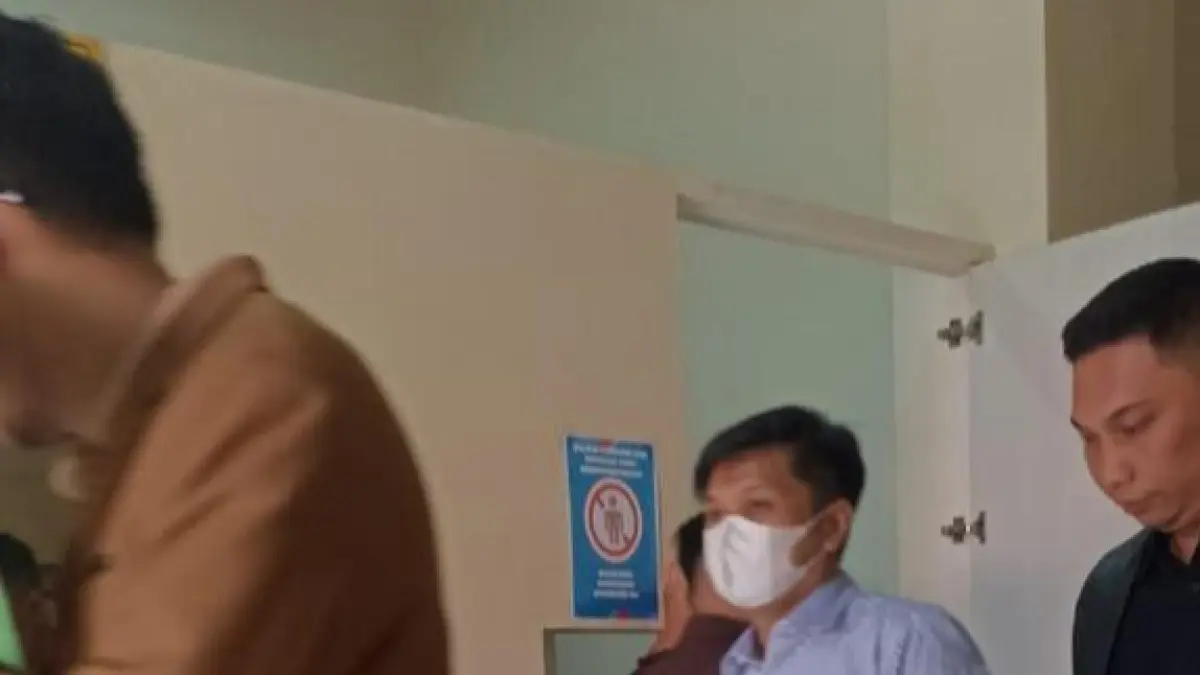 SIDANG PERDANA: Terdakwa HA (bermasker) memasuki ruang persidangan di PN Balikpapan