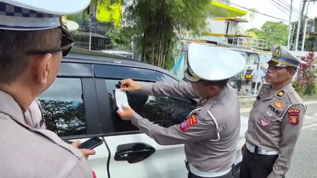 SANKSI: Selain sosialisasi oleh Satlantas Polresta Balikpapan, personel Gakkum Ditlantas Polda Kaltim memberi sanksi dengan menempel stiker tilang (ETLE Handheld) di kendaraan yang diparkir di area terlarang.