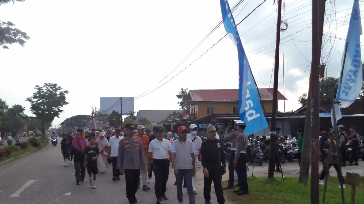 OLAHRAGA: Waris Muin (topi merah) mengikuti jalan santai sejauh 3 kilometer yang dipusatkan di halaman Kantor Disnakertrans PPU, Jumat (1/5/2026). (AHMAD MAKI/KP)
