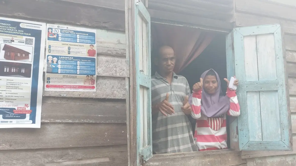 PENERIMA MANFAAT: M Nur (kanan) dan Aliansyah, buruh serabutan di Balikpapan menunjukkan kondisi dinding rumahnya. Ia merupakan salah satu penerima manfaat program BSPS tahun ini yang bersyukur akan mendapatkan bantuan perbaikan rumah. (DINA ANGELINA/KP)