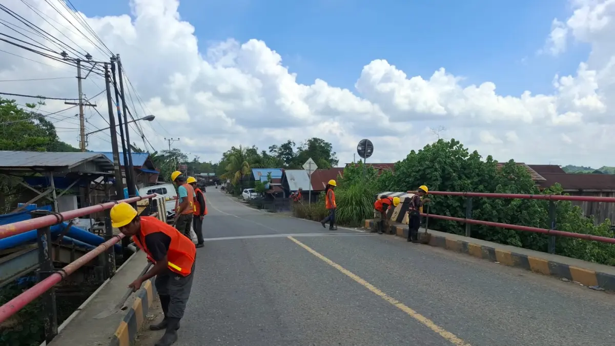 Petugas sedang membersihkan sedimen dan memangkas rumput liar di sekitar struktur jembatan ruas nasional Loa Janan–Tenggarong. (IST)